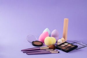 Kilka gąbek do makijażu leży na stole obok innych kosmetyków