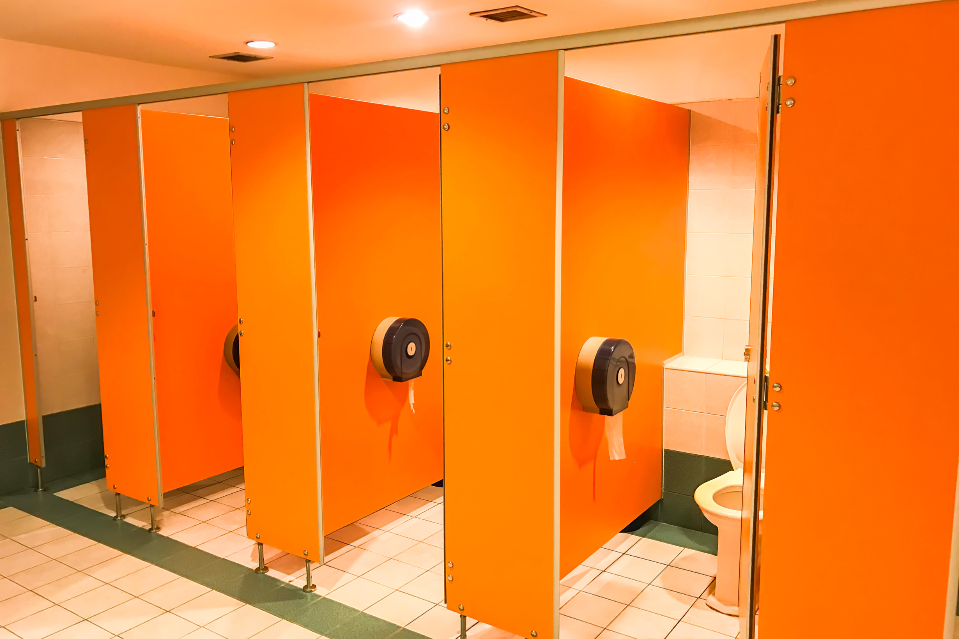 Pomarańczowe kabiny sanitarne stoją w miejscu publicznym